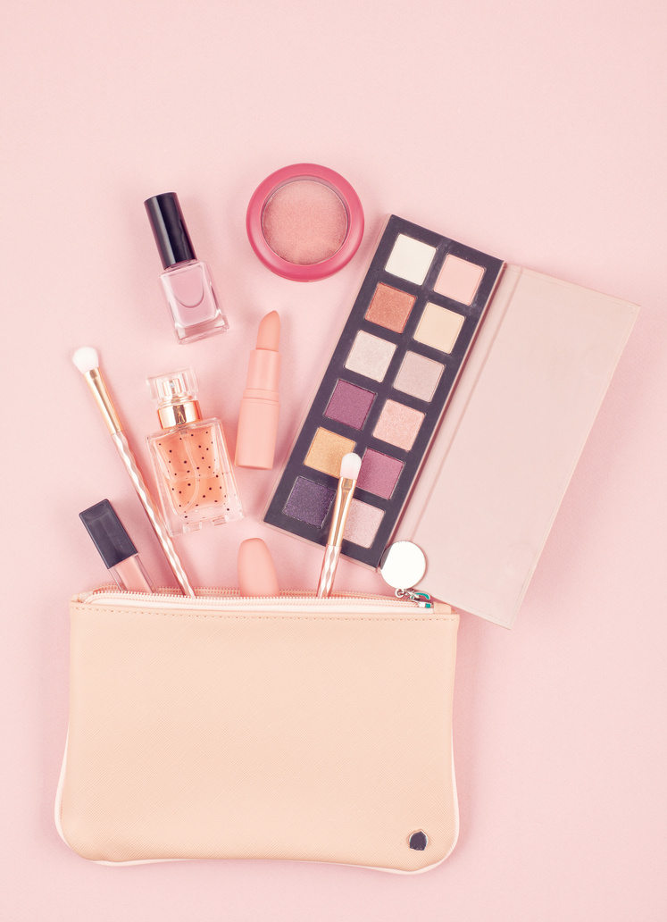 Makeup cosmetic products over pastel pink background, flat lay, top view